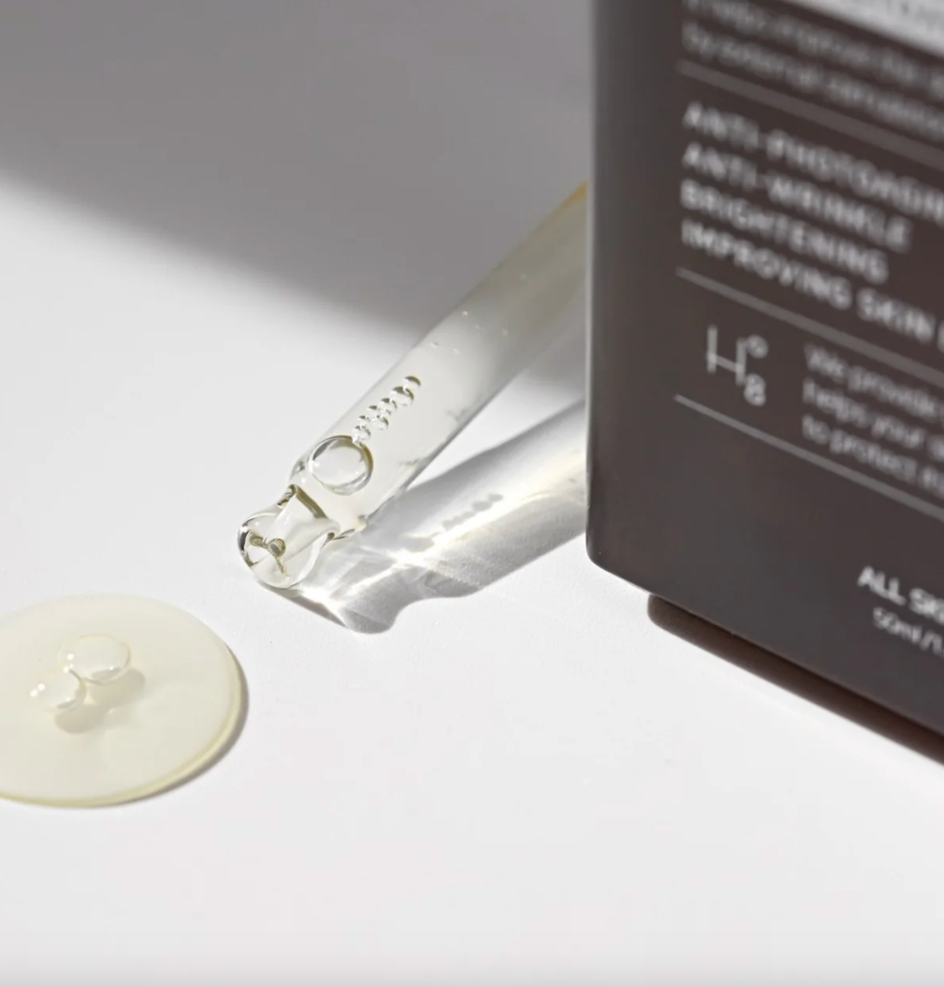 Close-up of serum drop flowing onto surface showing lightweight texture