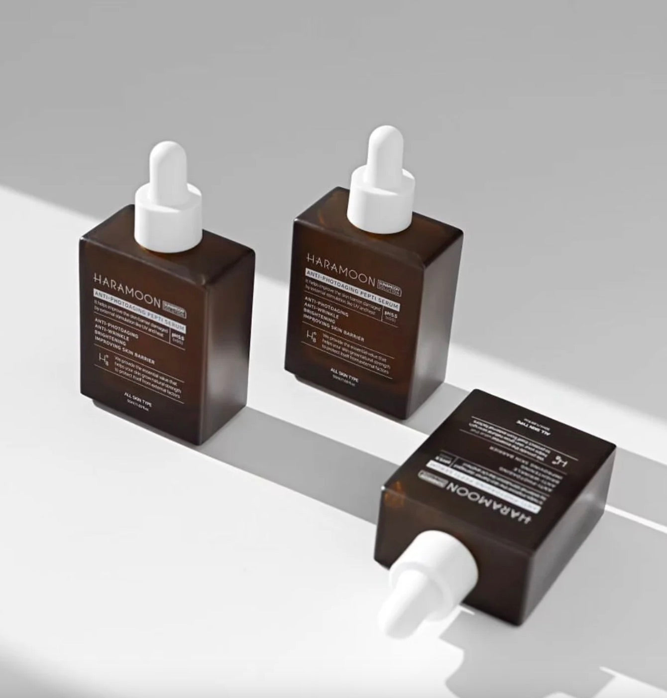 Dropper bottle of HARAMOON Immortal Peptide Serum on sunlit matte surface