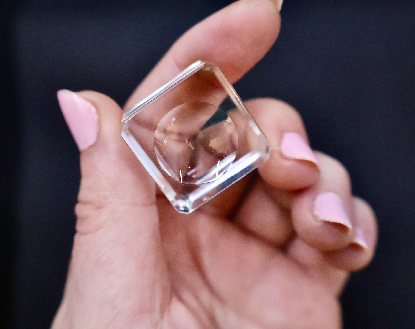 Crystal-clear acrylic glass stand with concave center, displayed on black background.