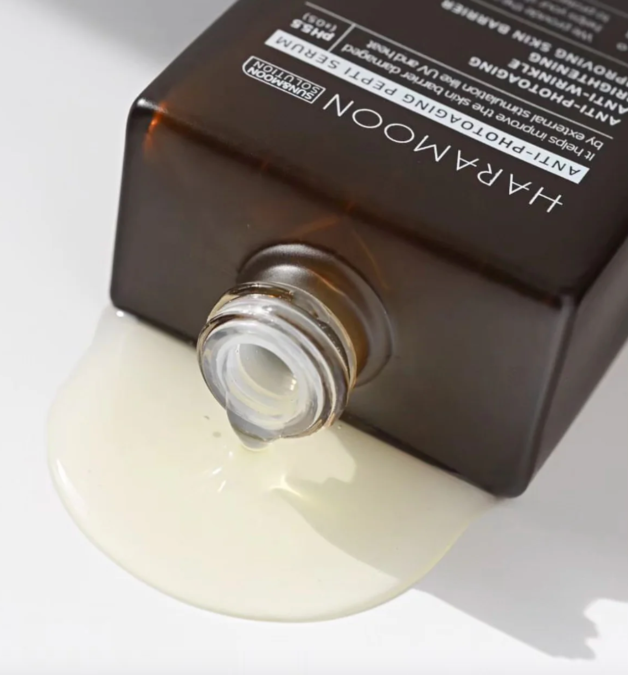 Close-up of serum drop flowing onto surface showing lightweight texture