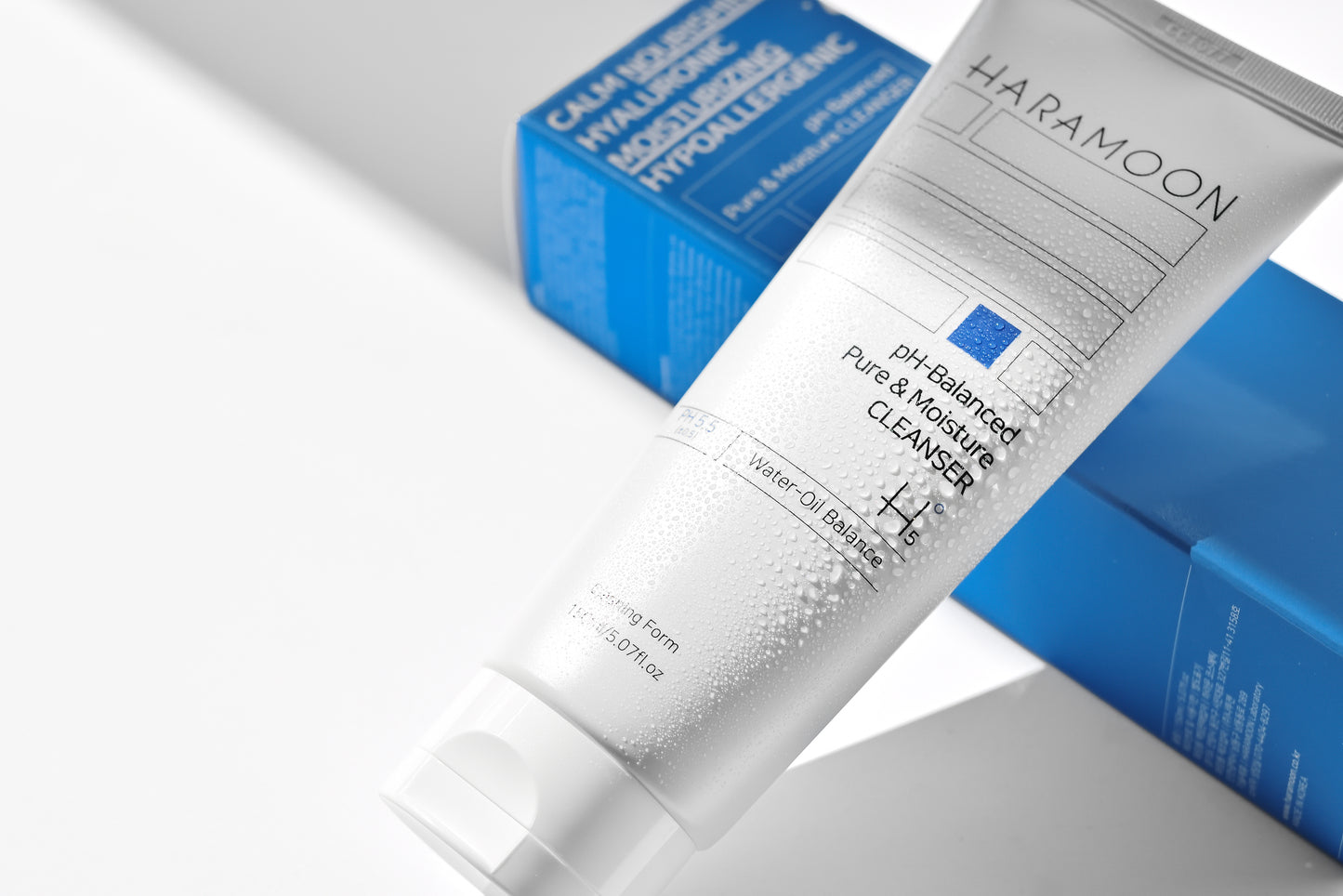 Tube of HARAMOON Pure Moisture Cleanser with water droplets on surface”