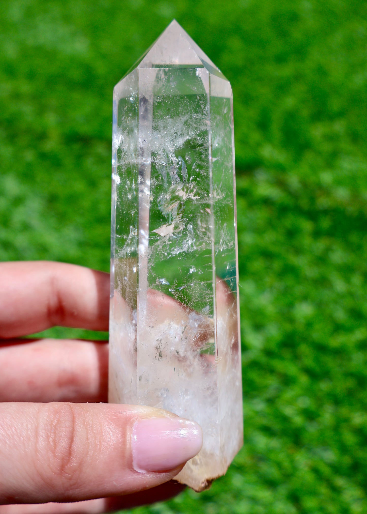 5 to 6 inch Brazilian clear quartz crystal point held in sunlight