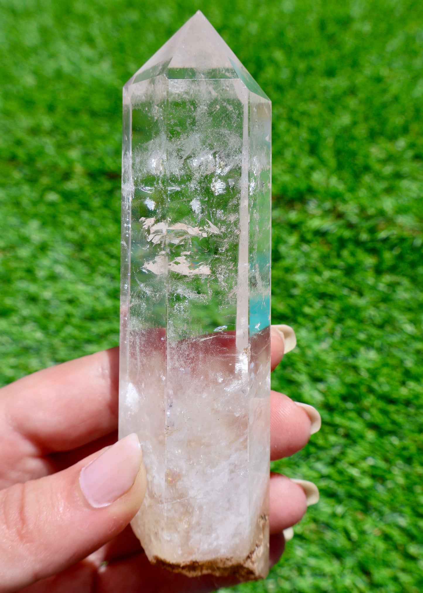 5 to 6 inch Brazilian clear quartz crystal point held in sunlight