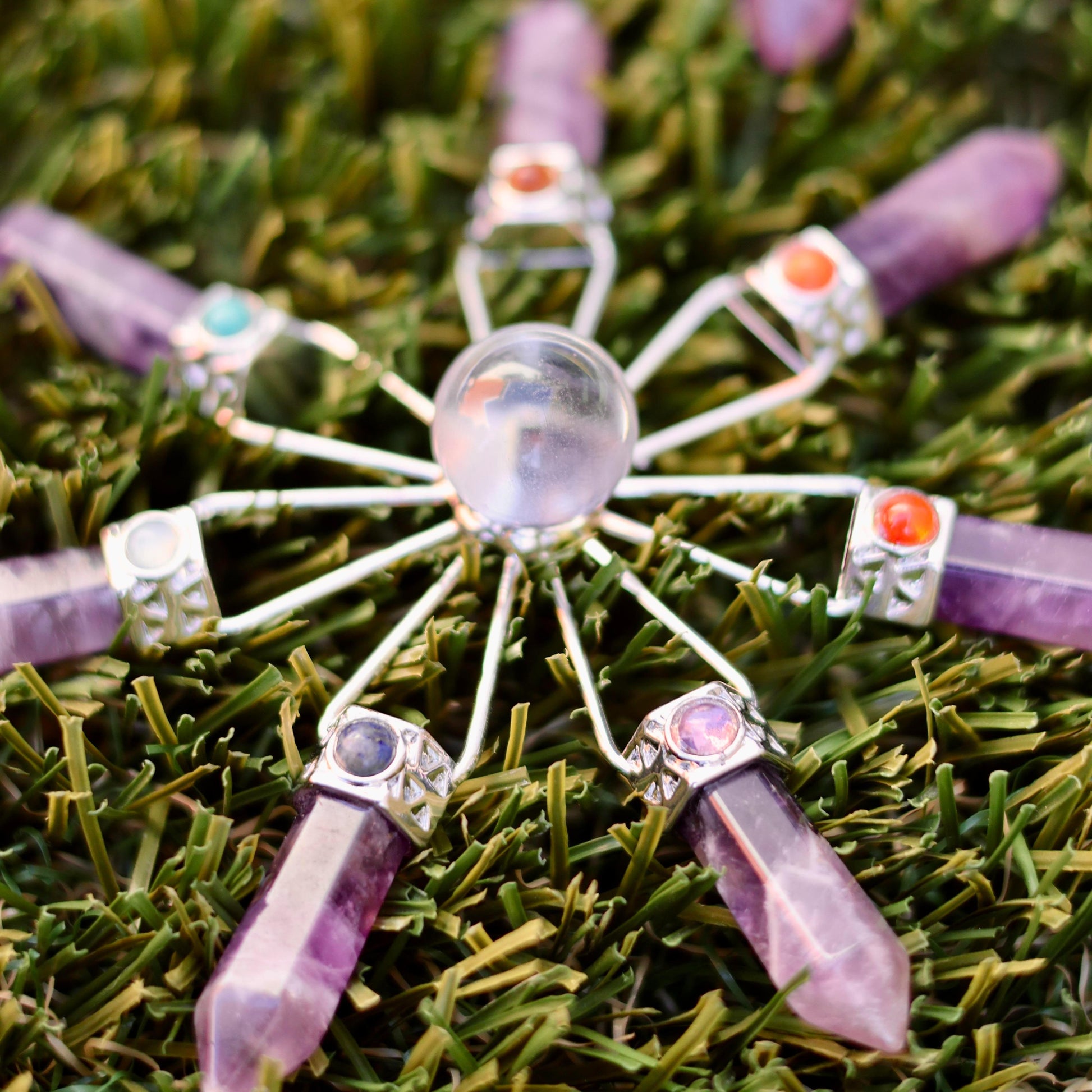 Amethyst crystal window suncatcher with geometric gold frame, catching sunlight