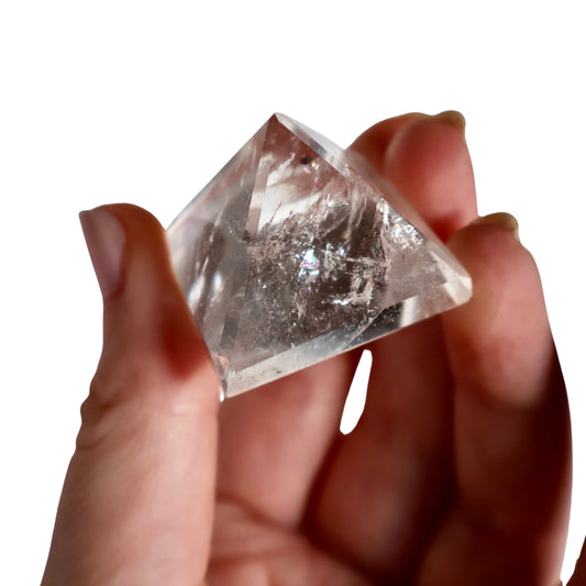 clear quartz pyramid in hand showing natural inclusions and angles