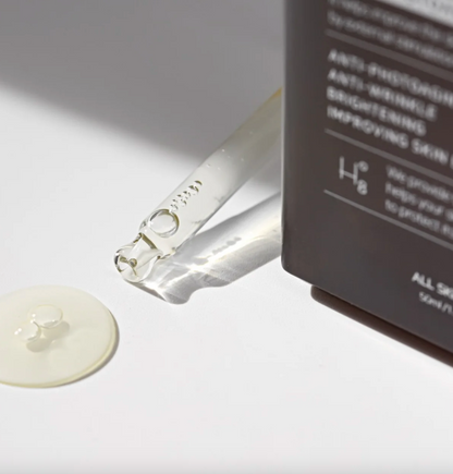 Close-up of serum drop flowing onto surface showing lightweight texture