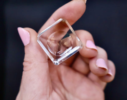 Crystal-clear acrylic glass stand with concave center, displayed on black background.