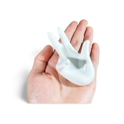 Glossy white ceramic hand-shaped display stand shown resting in an open palm for scale.