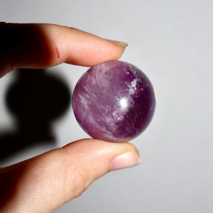 natural Amethyst Purple Crystal Sphere - Mini 0.75" in studio background