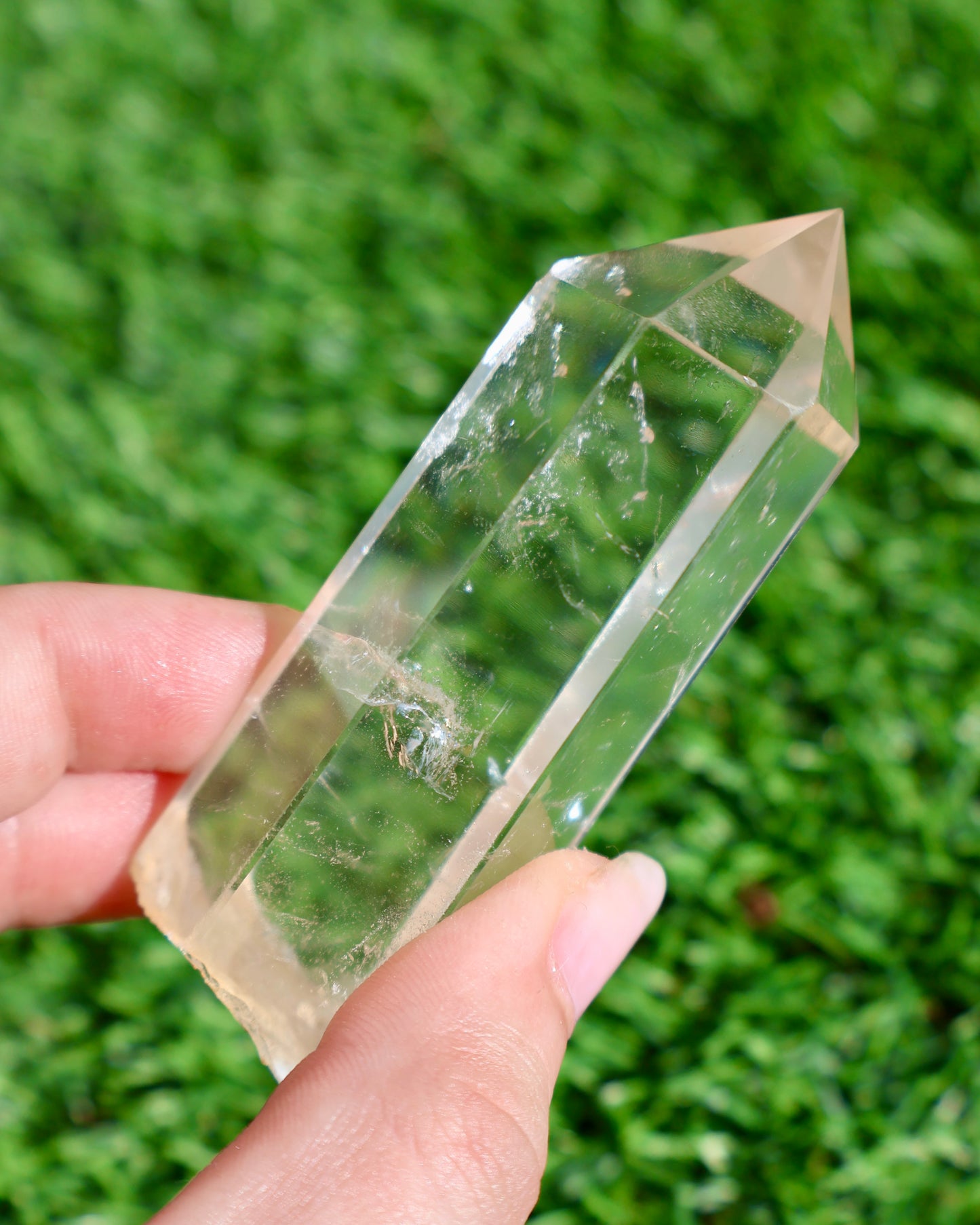 Thick clear quartz crystal wand with raw earthy base and polished point