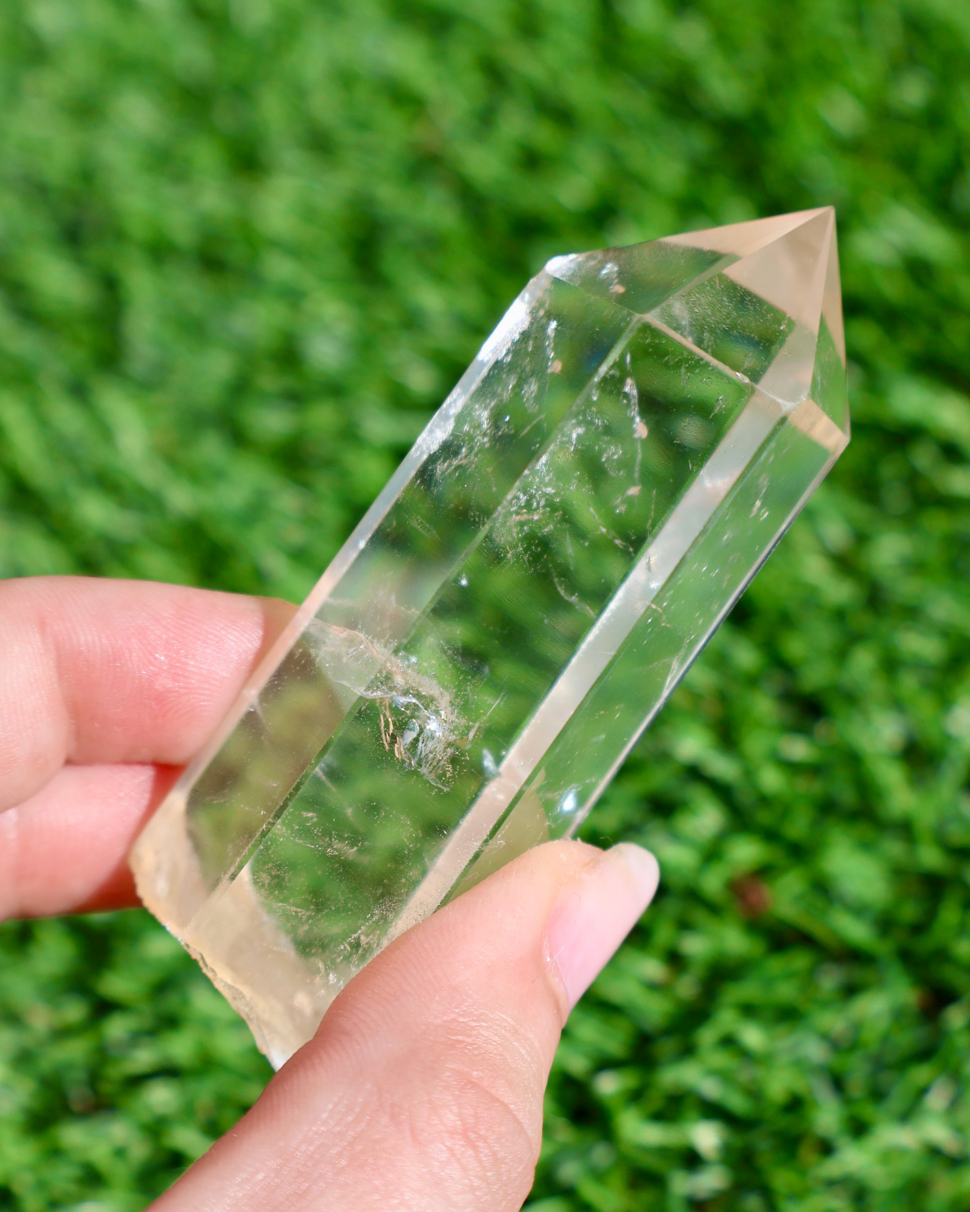 Thick clear quartz crystal wand with raw earthy base and polished point