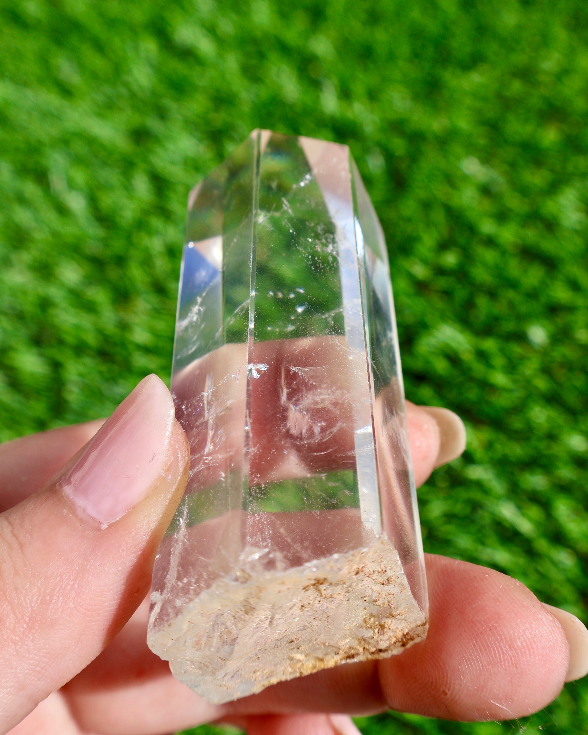 Thick clear quartz crystal wand with raw earthy base and polished point