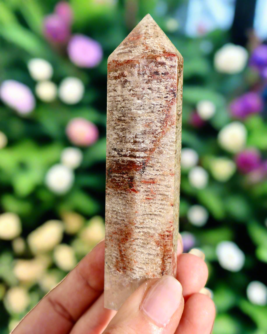 Crystal tower held in hand with grassy background
