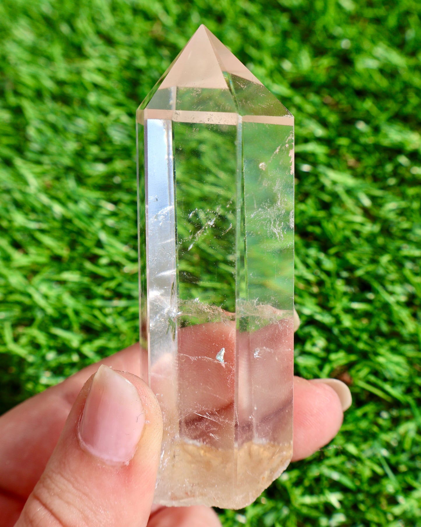 Thick clear quartz crystal wand with raw earthy base and polished point