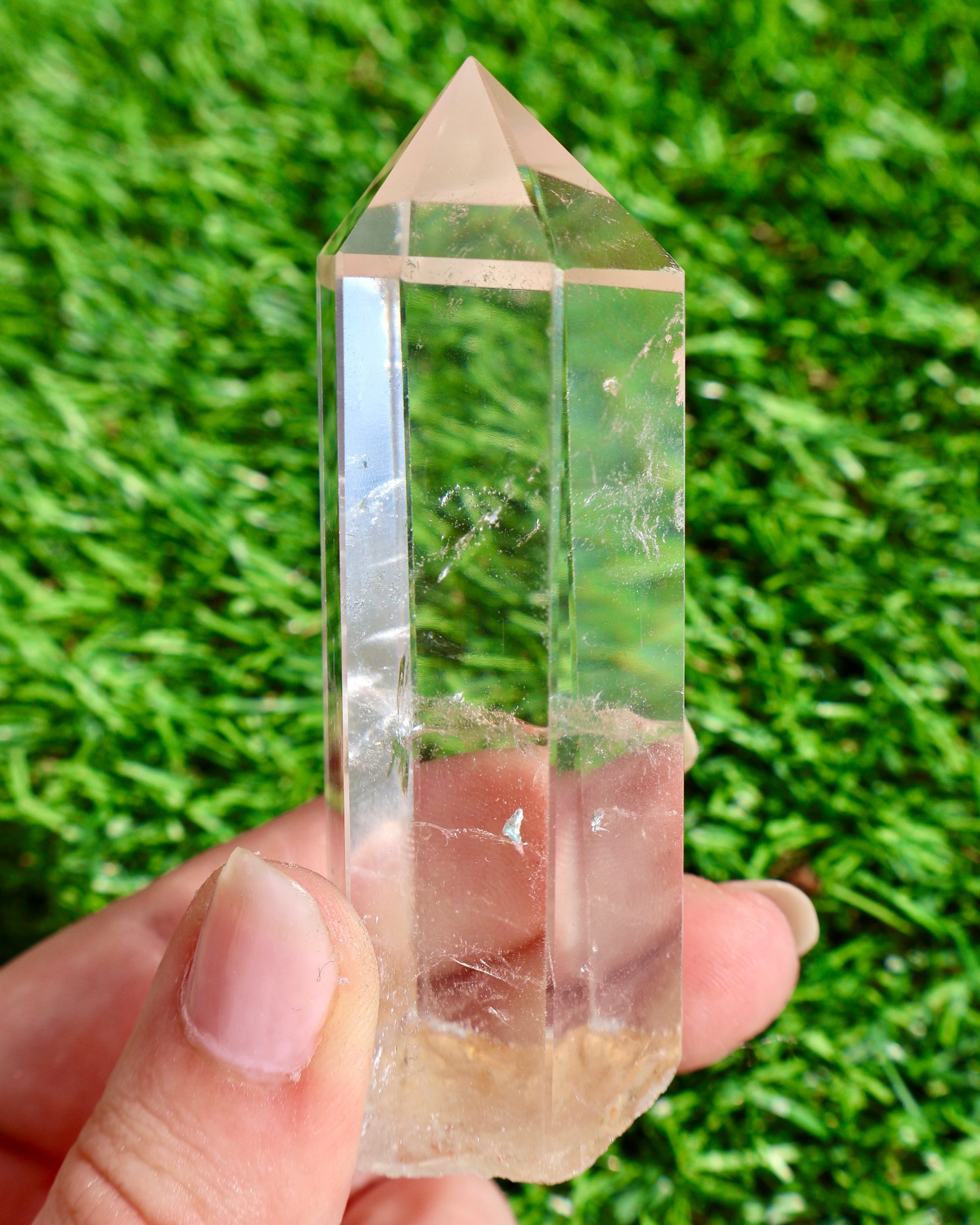 Thick clear quartz crystal wand with raw earthy base and polished point