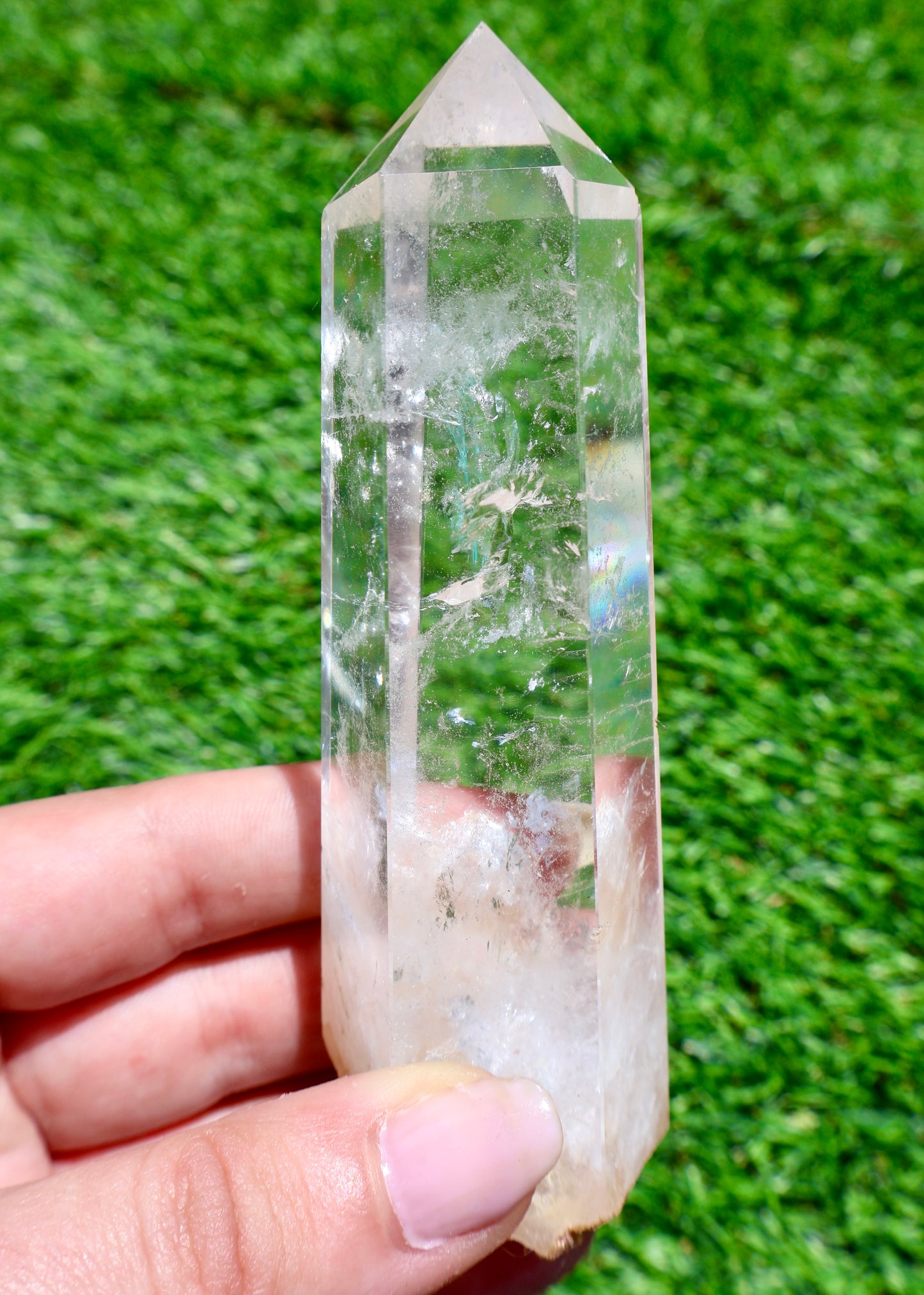 5 to 6 inch Brazilian clear quartz crystal point held in sunlight