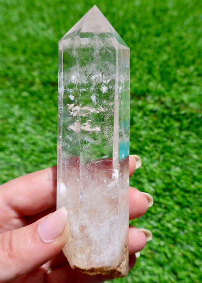 5 to 6 inch Brazilian clear quartz crystal point held in sunlight