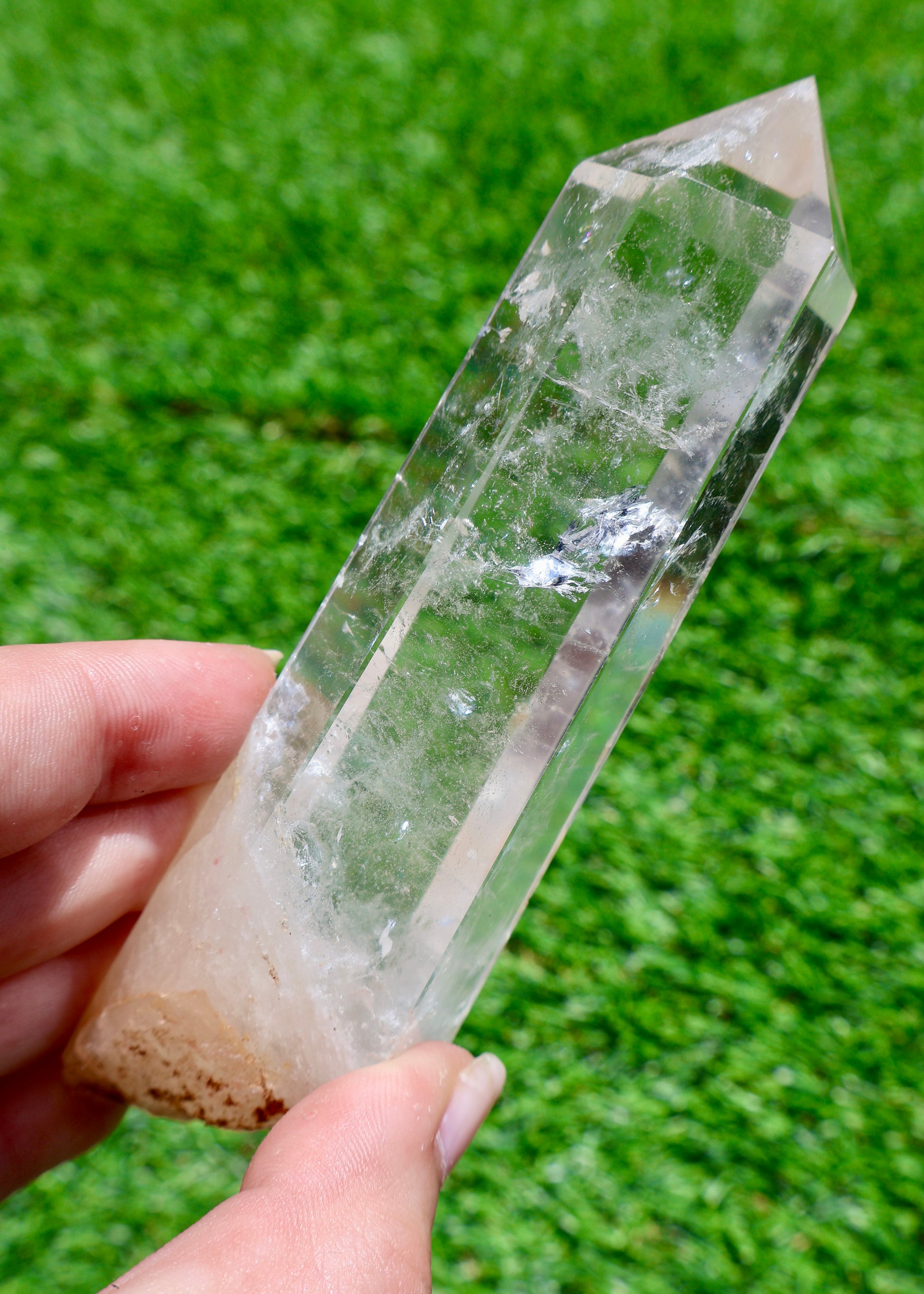 5 to 6 inch Brazilian clear quartz crystal point held in sunlight