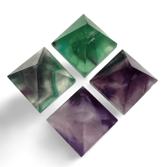Four crystal pyramids in green, purple, and multicolor on a white background