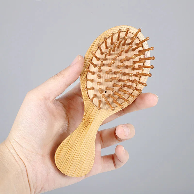 Eco-friendly handheld brush featuring a smooth bamboo base and rounded wooden bristles for comfortable hair brushing