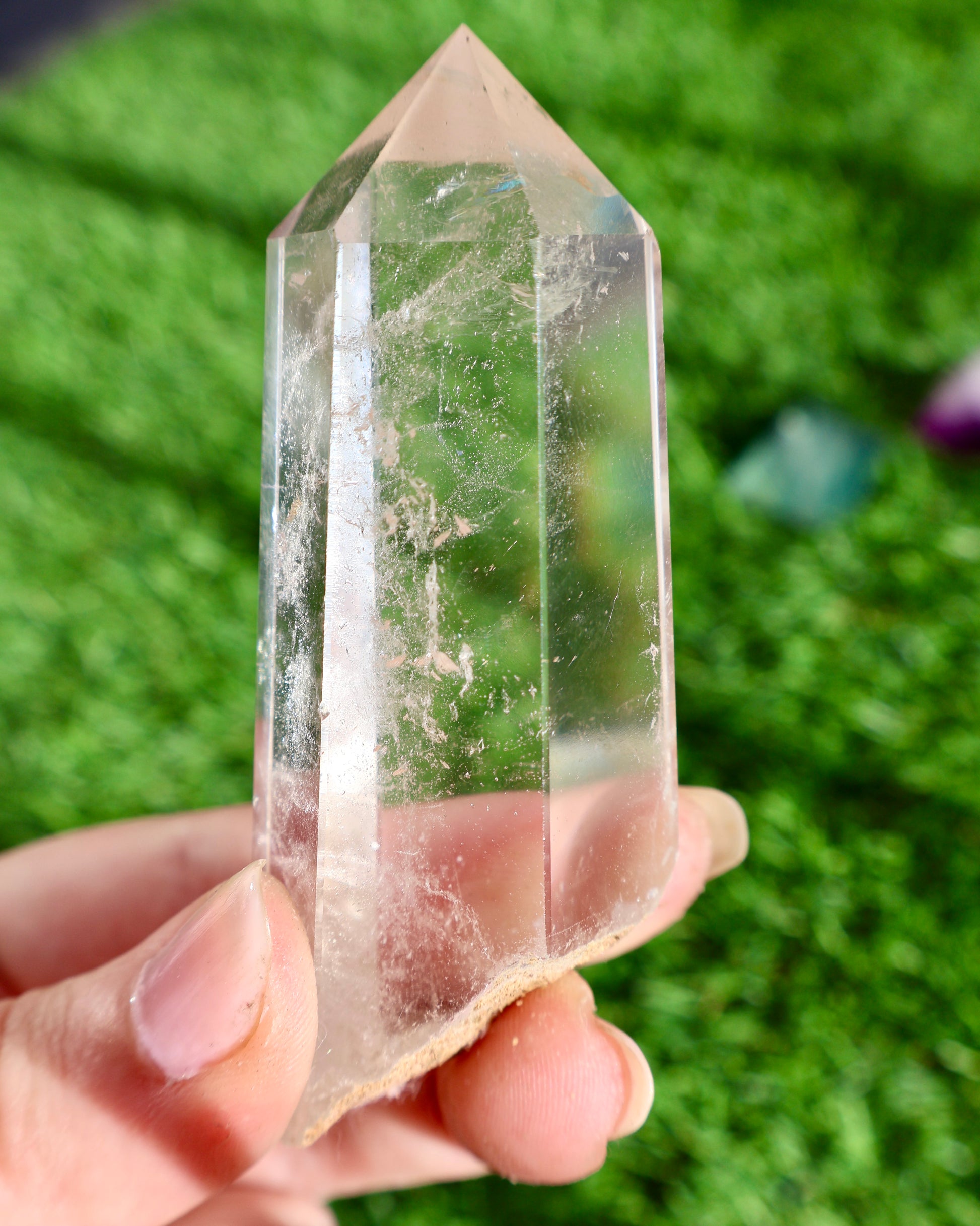 Thick clear quartz crystal wand with raw earthy base and polished point