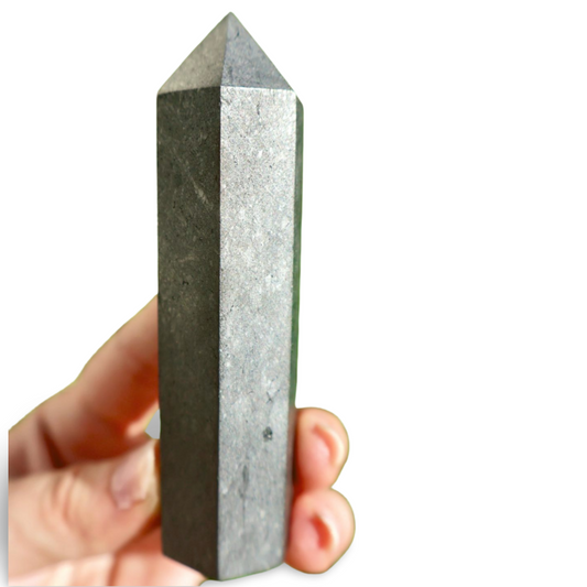 Hand holding a gray crystal pyramid against a white background