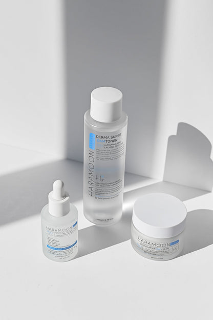 Skincare products including a bottle, dropper, and jar on a light background